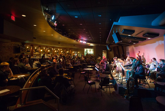 This side view of the Bop Stop shows two rows of barstool seating before a small band performance.